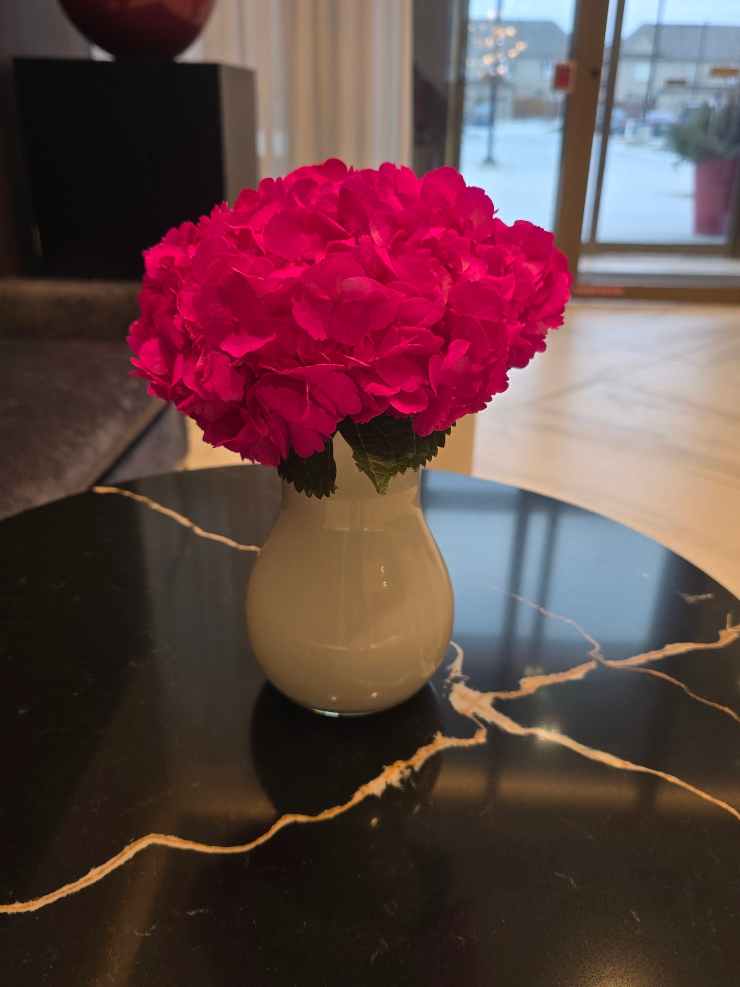Small white vase with tinted hot pink hydrengea